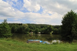 Boat on the pond shore and grassy bank
