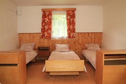 Cabin interior with three beds and floral curtains