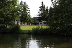Cabins behind the pond among trees
