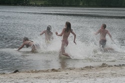 Children playing in the water by the sandy beach