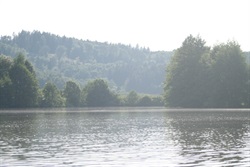 Misty view across the pond to wooded hills