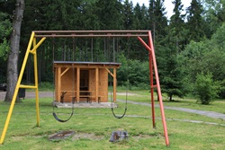 Swings with a wooden hut in the background