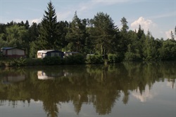 View across the pond to the camp and forest